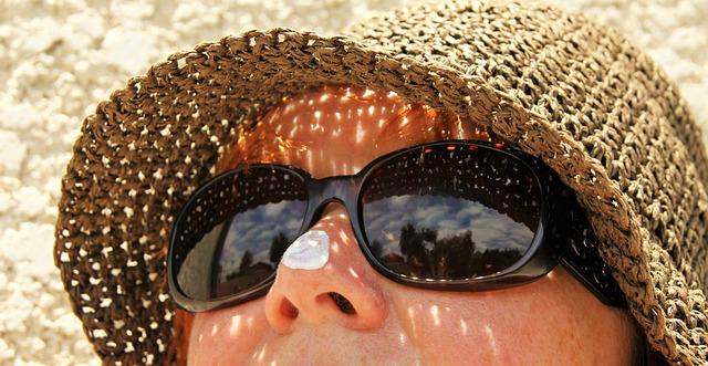 Frau trägt Sonnenbrille und Sonnenhut im Sommer